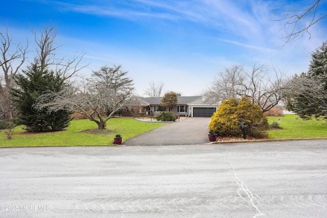 view of front of home featuring a front yard, an attached garage, and driveway