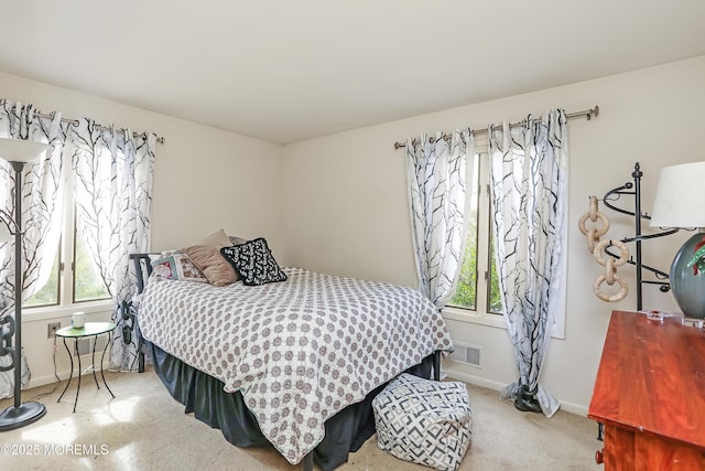 bedroom with visible vents, multiple windows, light colored carpet, and baseboards