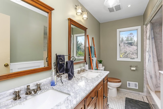 bathroom with toilet, visible vents, and a sink