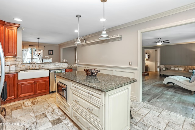 kitchen with stainless steel dishwasher, stone tile flooring, ornamental molding, and a sink