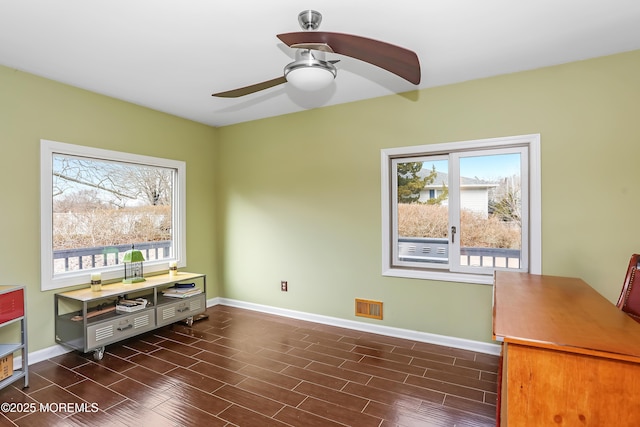 home office featuring baseboards, a wealth of natural light, and wood tiled floor