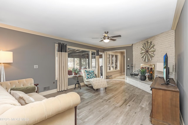 living room with visible vents, light wood-style floors, and ornamental molding