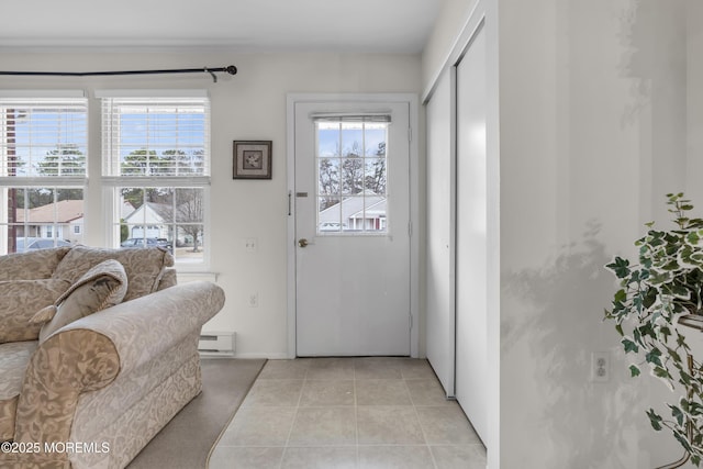 doorway with light tile patterned floors, a baseboard radiator, baseboards, and a wealth of natural light