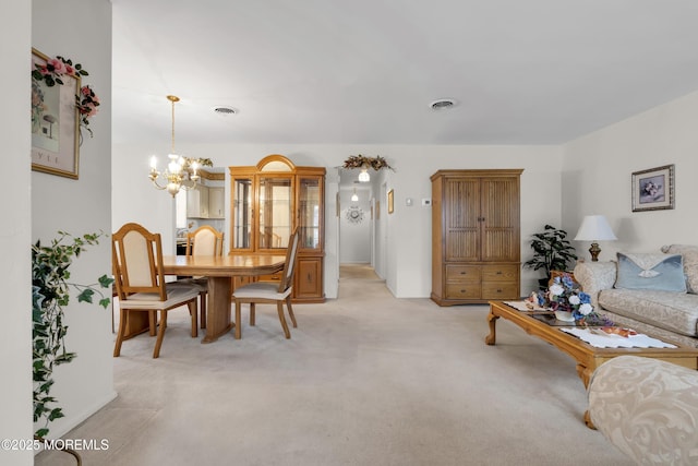 interior space featuring an inviting chandelier, visible vents, and light colored carpet