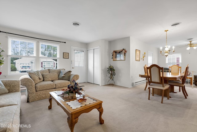 living room with an inviting chandelier, visible vents, baseboard heating, and light colored carpet