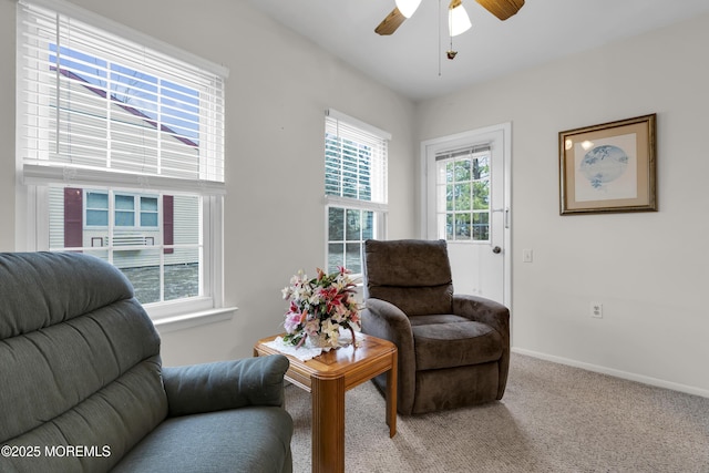 living area with carpet flooring, a ceiling fan, and baseboards