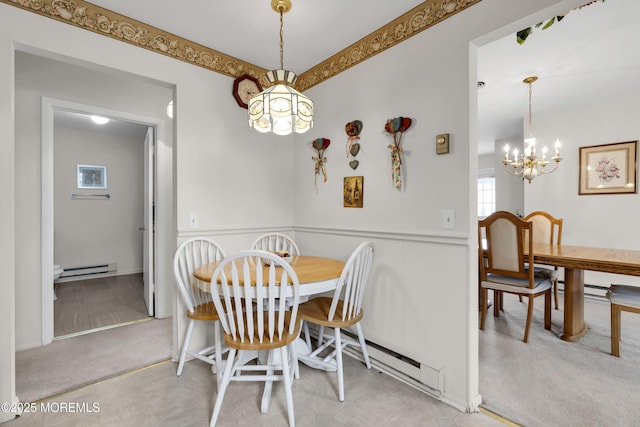 dining space featuring a wainscoted wall, a baseboard radiator, a notable chandelier, and light colored carpet