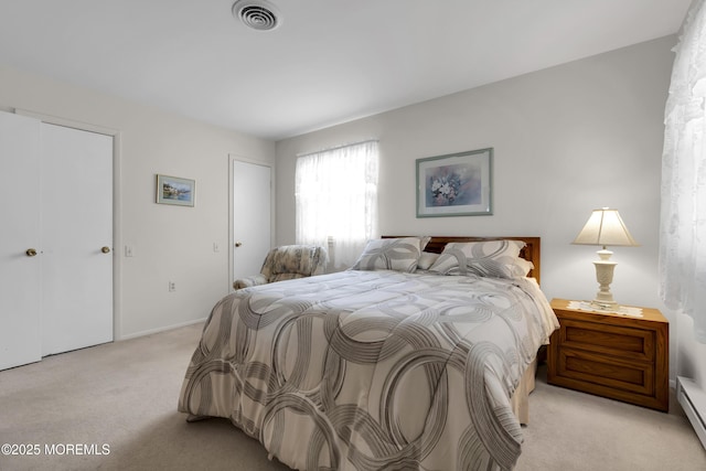 bedroom with visible vents, baseboard heating, and light colored carpet