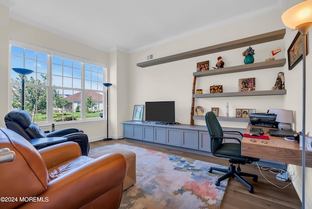 office space with ornamental molding, visible vents, baseboards, and wood finished floors