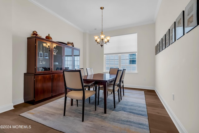 dining area with a notable chandelier, crown molding, baseboards, and wood finished floors