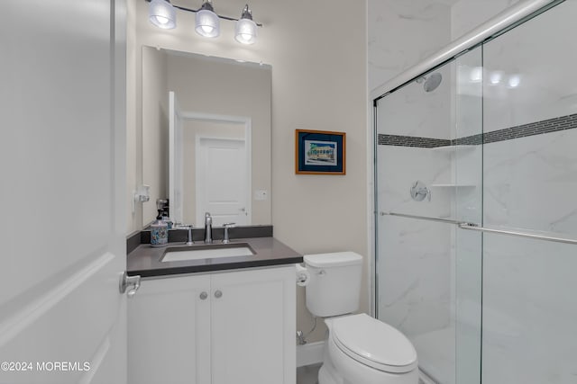 bathroom featuring a shower stall, toilet, and vanity