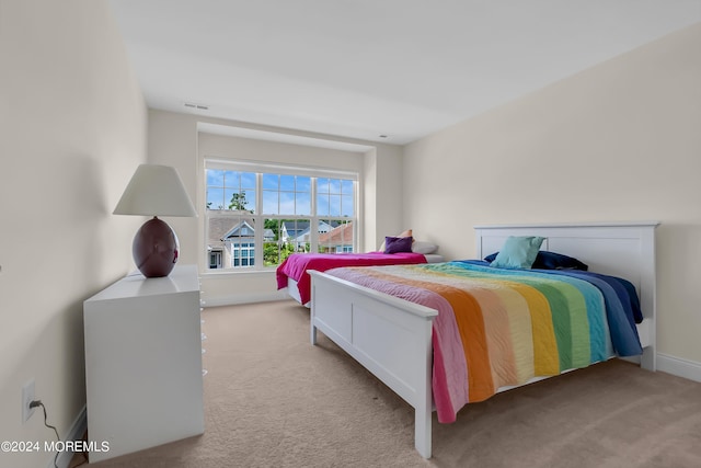 bedroom featuring carpet floors, visible vents, and baseboards