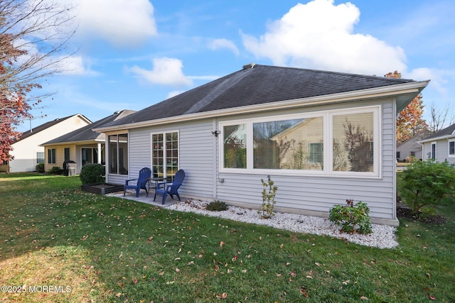 back of property with a patio area, a lawn, and roof with shingles