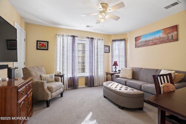 living room featuring visible vents, ceiling fan, and light carpet