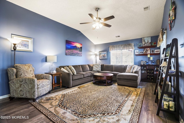 living room with vaulted ceiling, a textured ceiling, wood finished floors, and visible vents