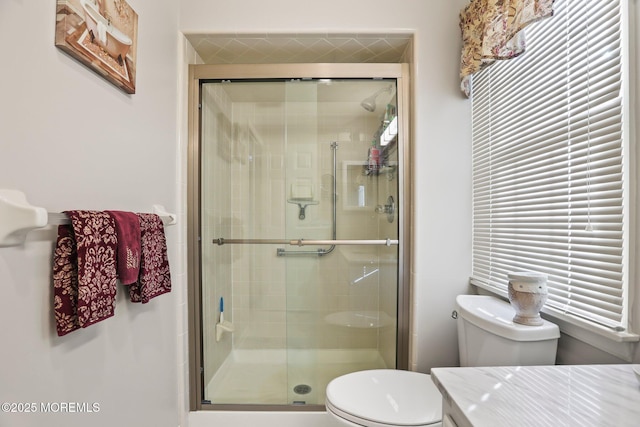 bathroom with a shower stall and toilet