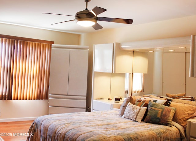 bedroom featuring a ceiling fan, light wood-type flooring, and baseboards