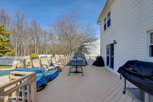 deck with outdoor dining area, area for grilling, and fence
