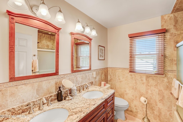 bathroom featuring a healthy amount of sunlight, tile walls, and a sink