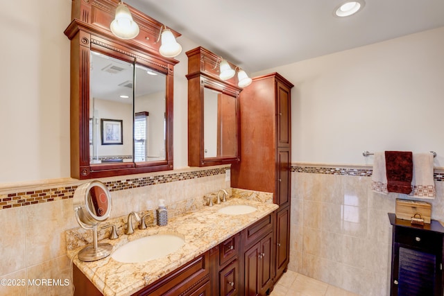 bathroom with double vanity, tile patterned floors, tile walls, and a sink