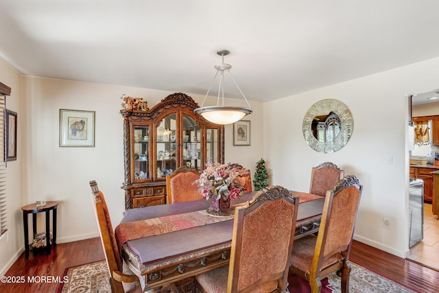 dining space featuring baseboards and wood finished floors