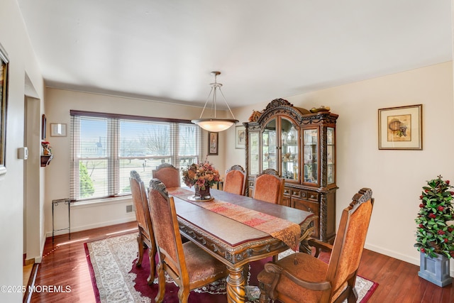 dining space featuring wood finished floors and baseboards