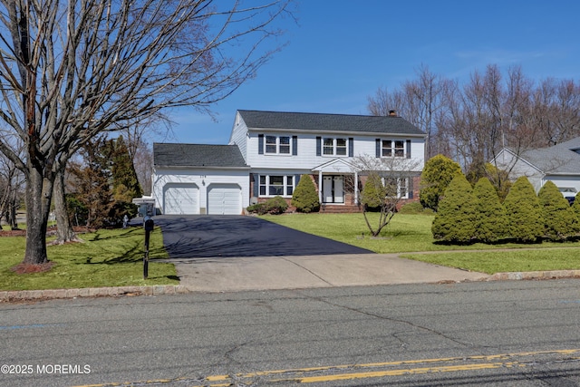 view of front of home featuring a garage, driveway, a chimney, and a front yard