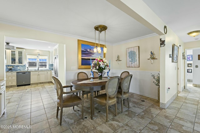 dining area featuring a wainscoted wall, ornamental molding, and light tile patterned floors