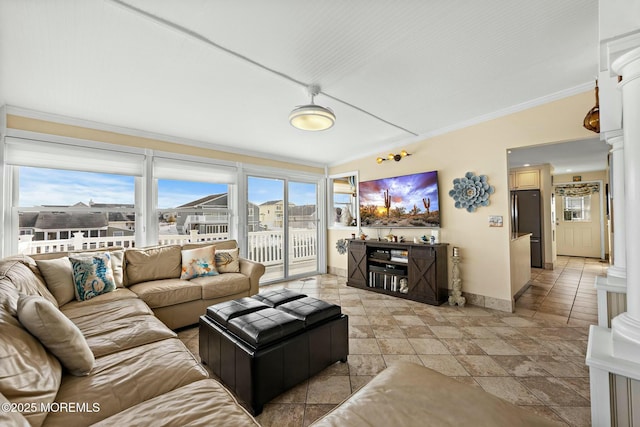 living room with baseboards, decorative columns, and crown molding