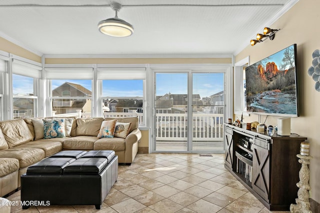 living room with light tile patterned floors, ornamental molding, and a wealth of natural light