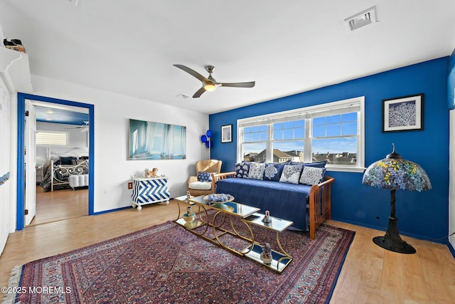 bedroom with baseboards, wood finished floors, visible vents, and a ceiling fan