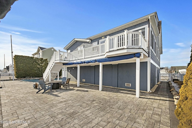 rear view of house with a fire pit, a patio, stairs, fence, and a deck