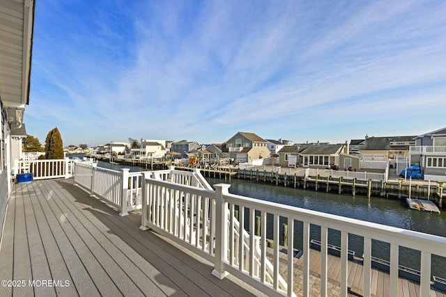 wooden terrace with a water view and a residential view