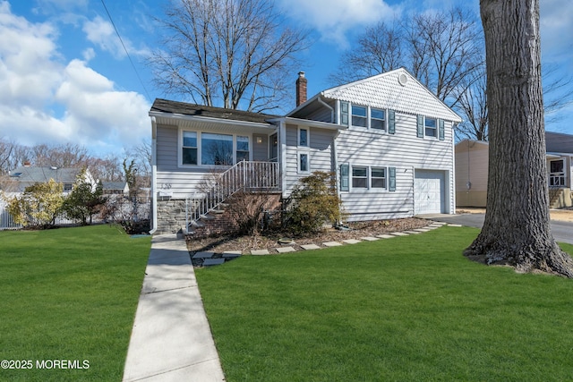 tri-level home featuring driveway, a front lawn, a chimney, and an attached garage