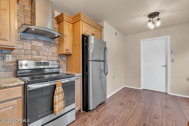 kitchen featuring wood finished floors, stainless steel appliances, extractor fan, light brown cabinetry, and backsplash