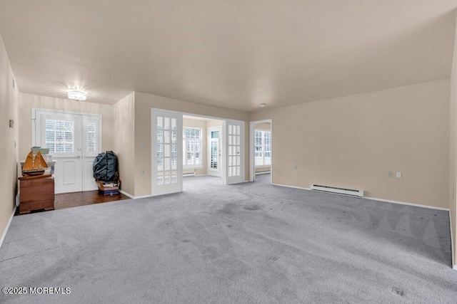 unfurnished living room featuring baseboards, a baseboard heating unit, and carpet flooring