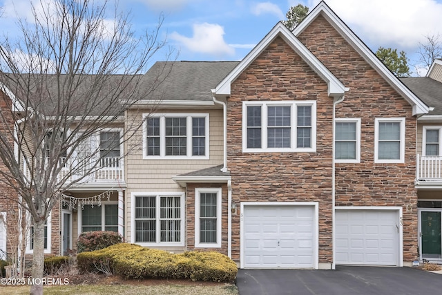 townhome / multi-family property with driveway, a garage, and roof with shingles