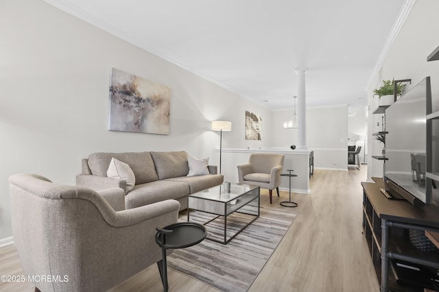 living area with ornamental molding, an inviting chandelier, light wood-style flooring, and baseboards