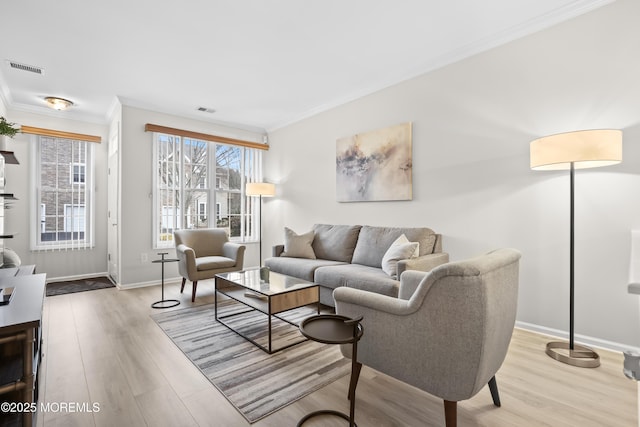 living area featuring wood finished floors, visible vents, and crown molding