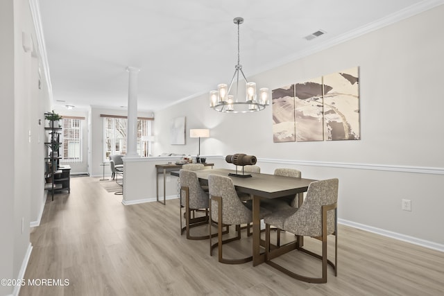 dining area featuring baseboards, light wood-type flooring, visible vents, and crown molding