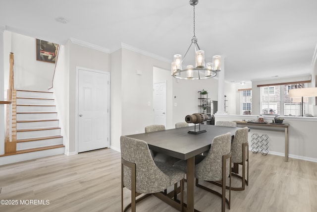 dining room with ornamental molding, light wood-type flooring, baseboards, and stairs