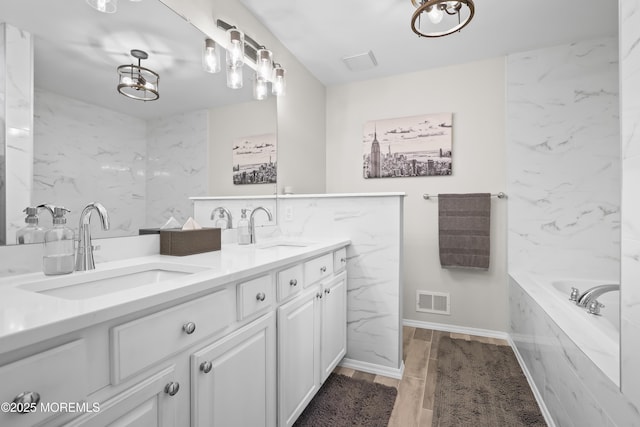 full bathroom with tile walls, visible vents, and a sink