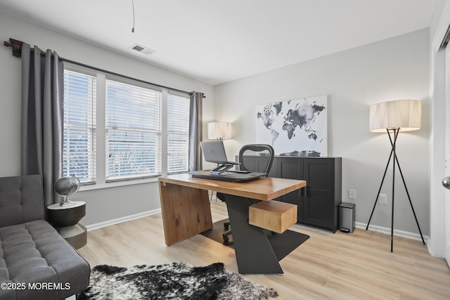 office space with baseboards, visible vents, and light wood finished floors