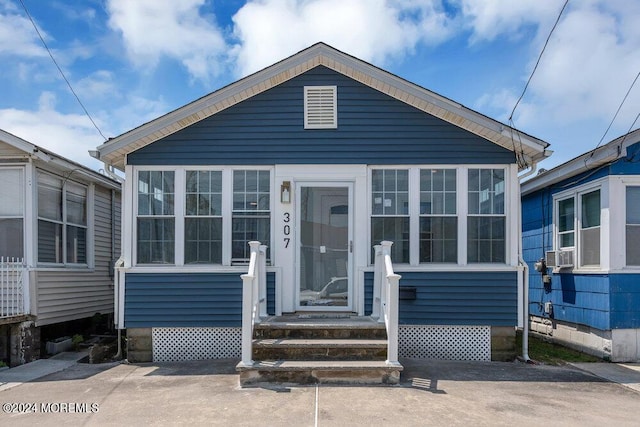 view of front facade with cooling unit and a sunroom