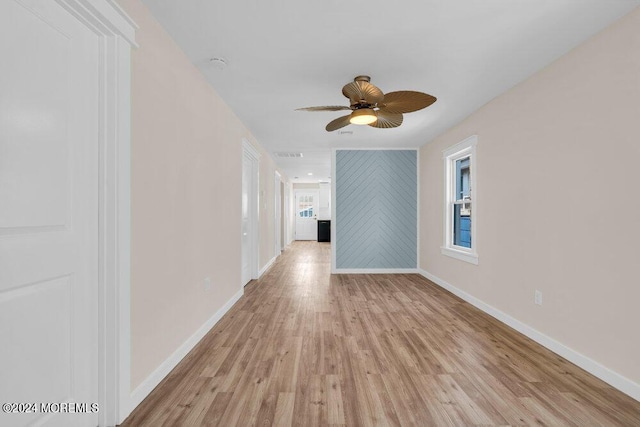 unfurnished living room featuring ceiling fan, visible vents, light wood-style flooring, and baseboards