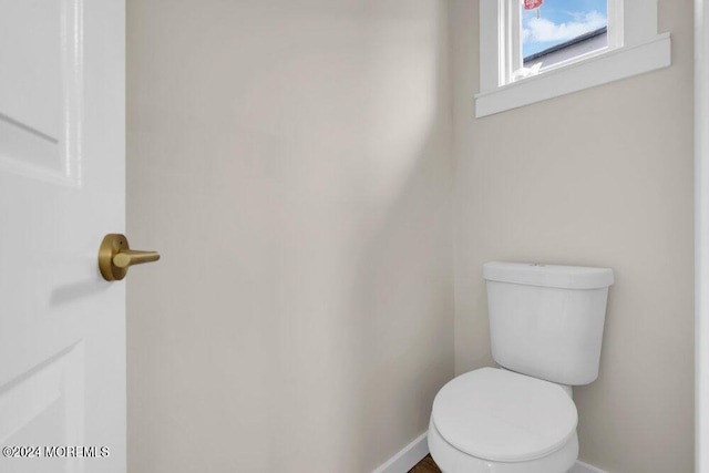 bathroom with toilet and baseboards