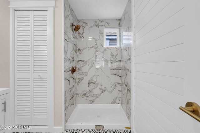 bathroom with a closet and a marble finish shower