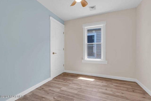 unfurnished room featuring light wood-type flooring, visible vents, and baseboards