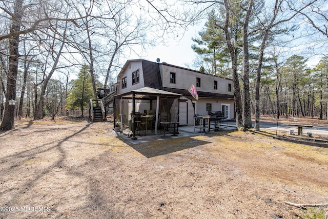 back of property with a patio area, a gazebo, stairs, and a gambrel roof