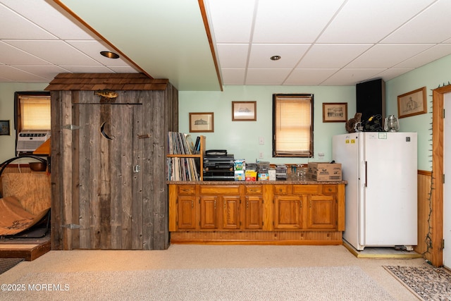 bar featuring a paneled ceiling, light colored carpet, cooling unit, and freestanding refrigerator